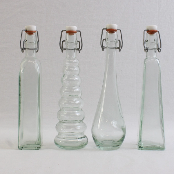 Lot Of 4 Matching 8" Tall Clear Glass Empty Decorative Bottles Assorted Shapes