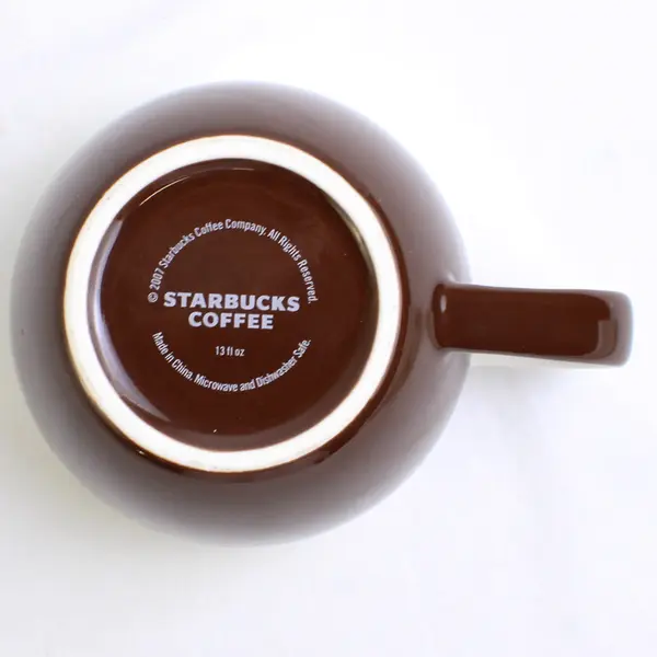 2007 Starbucks Mug with Writing Across Brown and White 13 fl oz.
